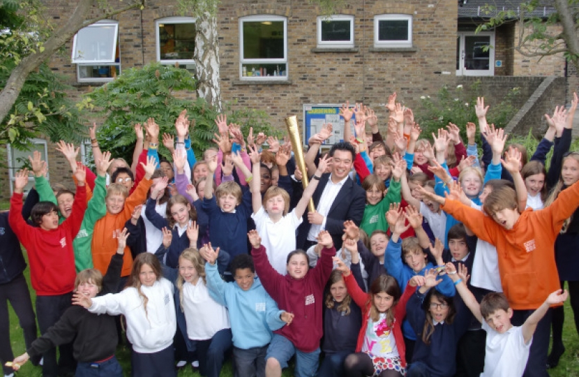 Alan Mak with the Olympic Torch at a school talk 