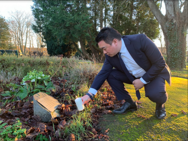 Local MP Alan Mak lights a candle at the Havant cemetery, pausing to remember victims of the Holocaust and other genocides