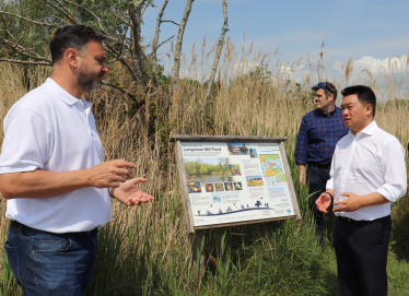 Photo: Alan Mak MP inspects the Langstone Mill Pond and surrounding area with Lyall Cairns, Head of Coastal Partners.